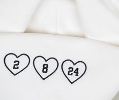 three hearts with the number eight on them are embroidered onto a t - shirt that says love