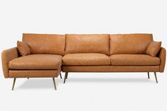 a tan leather couch sitting on top of a white floor