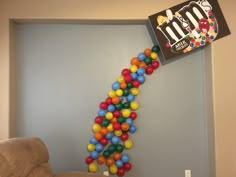 a bunch of balls hanging from the side of a wall next to a chair and box