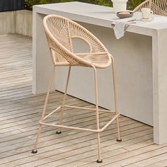 an outdoor bar with a table and stools on the wooden floor next to it