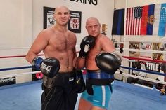 two men standing next to each other in a boxing ring with gloves on their hands