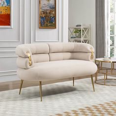 a white couch sitting in a living room on top of a hard wood floor next to a table