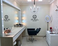 a hair salon with chairs and lights on the wall, mirrors in front of it