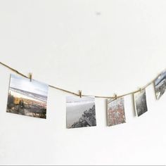 some pictures hanging on a rope with clothes pins