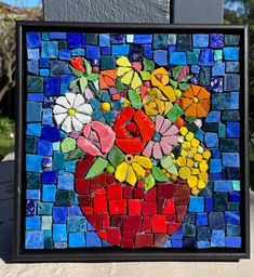 a colorful mosaic with flowers in a vase