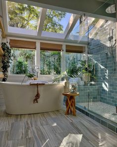 a bathroom with a large bathtub next to a walk in shower and two windows