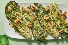 grilled asparagus with parmesan cheese and herbs on a white plate