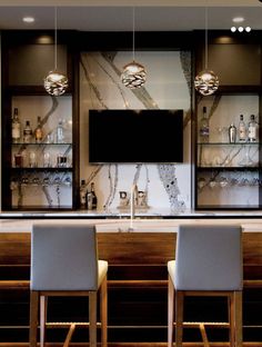 a bar with chairs and a television mounted to the wall