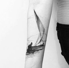 a person with a sailboat tattoo on their arm