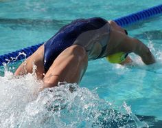 a woman swimming in a pool with her head above the water