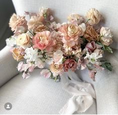 a bouquet of flowers sitting on top of a white chair