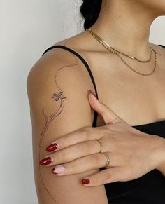 a woman's arm with a flower tattoo on the left side of her arm