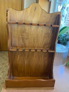 an old wooden book case sitting on top of a table next to a potted plant