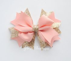 a pink bow with gold glitters on it