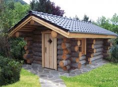 a small log cabin is made out of logs and has a slate roof with shingles