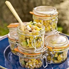 four jars filled with food sitting on top of a blue plate