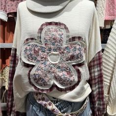 a woman's sweater with flower appliqued on it