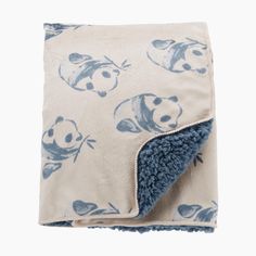 a blue and white blanket with pandas on it's side, folded up