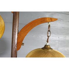 two yellow lamps hanging from a wooden pole