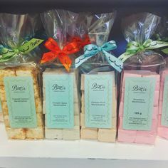 several different types of soaps are on display in plastic bags with ribbons around them