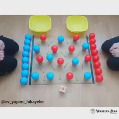 two people sitting on the floor playing with balls and plastic chairs in front of them