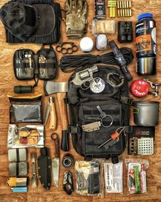 an assortment of personal items laid out on a wooden table, including gloves, knifes, scissors and other things