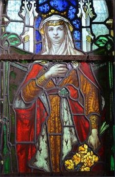 a stained glass window with a woman holding a flower in her hand and wearing a crown