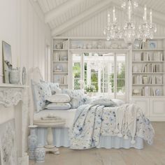 a bedroom with white walls and wooden floors has a chandelier hanging from the ceiling