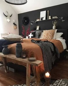 a bed room with a neatly made bed next to a wooden table and two candles