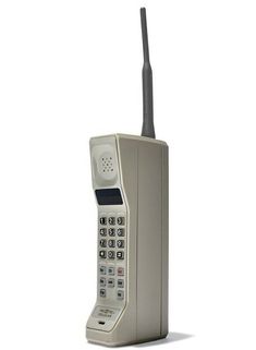 an old style cell phone sitting on top of a white surface