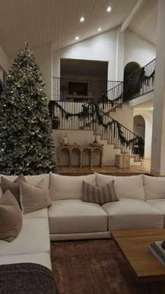 a living room filled with furniture and a christmas tree in the middle of the room