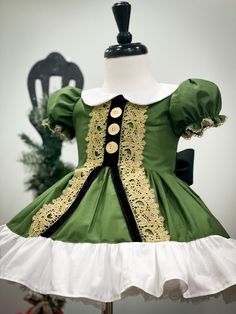 a green and white dress sitting on top of a mannequin