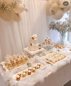 a table topped with cakes and cupcakes next to balloons in the shape of snowflakes