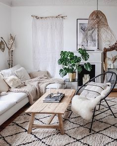 a living room filled with white furniture and lots of plants on top of a rug