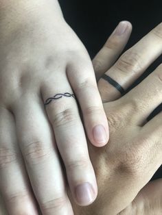 two people with wedding rings on their fingers are holding each other's hand together