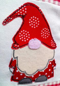 a close up of a red and white shirt with a gnome on it