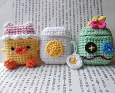 three small crocheted items sitting on top of an open book