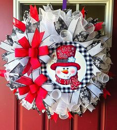 a red and white wreath with a snowman on it