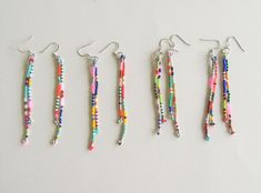 four pairs of beaded earrings hanging from hooks