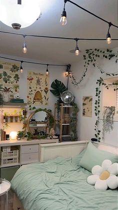 a bedroom with lots of plants on the wall and lights hanging from the ceiling over the bed