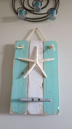 a wall hanging with a starfish on it and some hooks attached to the wall