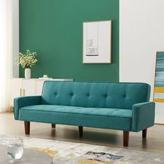 a living room with green walls and a blue couch in the middle, next to a coffee table