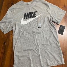 Grey Nike Logo Tshirt Athletic Heather Short Sleeve T-shirt With Logo, Nike Cotton Shirt With Relaxed Fit, Casual Cotton T-shirt In Athletic Heather, Nike Gray Graphic Print Top, Nike Athletic Heather Graphic Print Top, Nike Gray T-shirt With Logo Print, Nike Cotton Crew Neck Shirt, Nike Athletic Heather Crew Neck T-shirt, Cotton Athletic Heather T-shirt With Logo Print