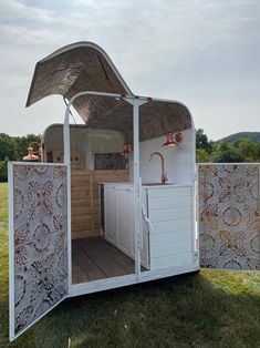 a white trailer with an awning and sink in the back