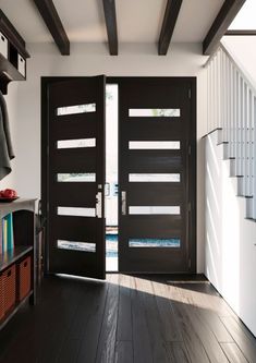 two black doors are open on the inside of a room with dark wood floors and white walls