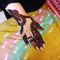 a woman's hand with henna tattoos on it