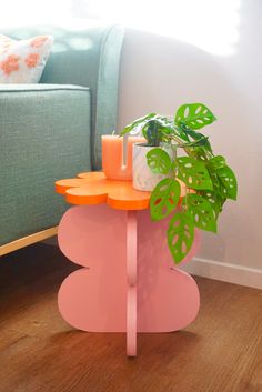 a plant is sitting on top of a pink table