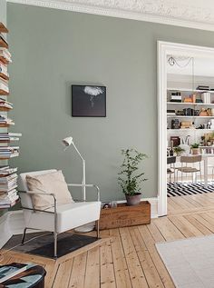 a living room filled with furniture and bookshelves next to a doorway that leads into a dining room