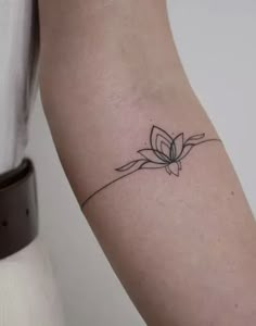 a woman's arm with a small flower tattoo on the left side of her arm