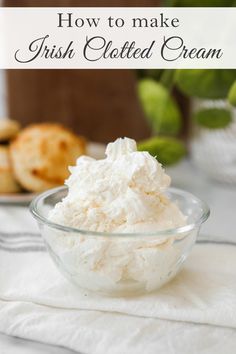 a glass bowl filled with whipped cream on top of a white towel next to some cookies